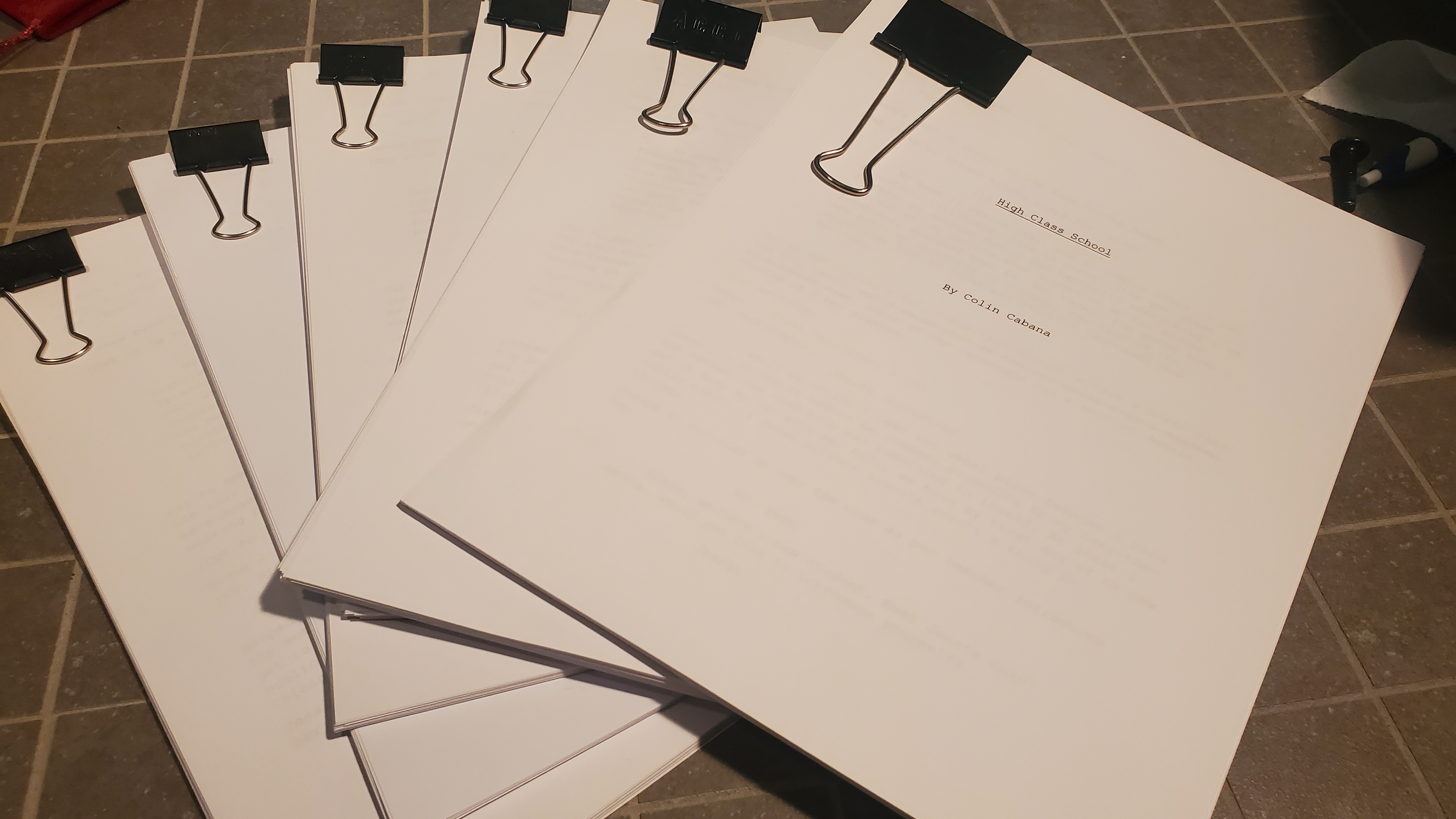 Image of several physical paper copies of a screenplay.